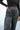 Close upper front view of model wearing the Wish Upon A Star Pants, that have black fabric with metallic silver threads, an elastic band, and flared legs.