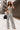 Full body front view of model wearing the Going Rogue Pants, which have an ivory and black geometric print, a high-rise waist, a wide leg fit, and a back zipper closure. Worn with matching top.