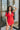 Frontal view of the Speechless Romper that features a red chiffon material, a surplice neckline, a short sleeve with a slit, a waist tie detail, a faux wrap skirt overlay, a shorts back, and a back zipper closure.