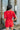 Back view of the Speechless Romper that features a red chiffon material, a surplice neckline, a short sleeve with a slit, a waist tie detail, a faux wrap skirt overlay, a shorts back, and a back zipper closure.