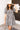 Front view of model wearing the Go Your Own Way Dress, which has a black and ivory plaid pattern, a straight neckline, a puffy half sleeve, pockets, a back zipper closure, and a mini length