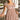Front view of model wearing the Happy And Free Babydoll Dress, which has a brown gingham print, a straight neckline, a short puffy sleeve with, a parachute bottom, an elastic bottom hem, and a back zipper closure.