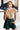 Front view of model wearing the Meet Me In Maine Sweater Tank in Taupe that has a stretchy cable knit material, a turtleneck, a sleeveless design, and a thick bottom hem. Tucked into shorts.
