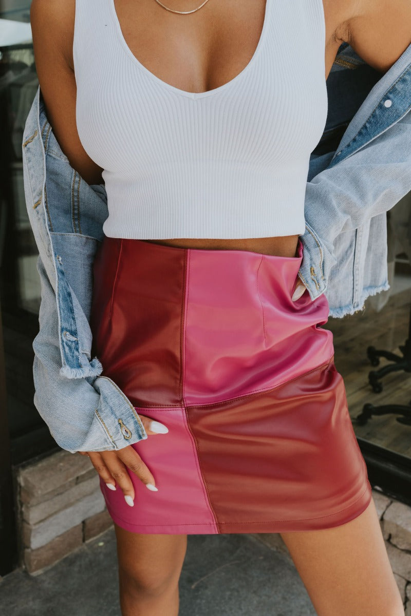 Frontal view of the Born Diva Color-Block Skirt that features a faux leather material, a color block design, a high-rise waist, and a back zipper closure