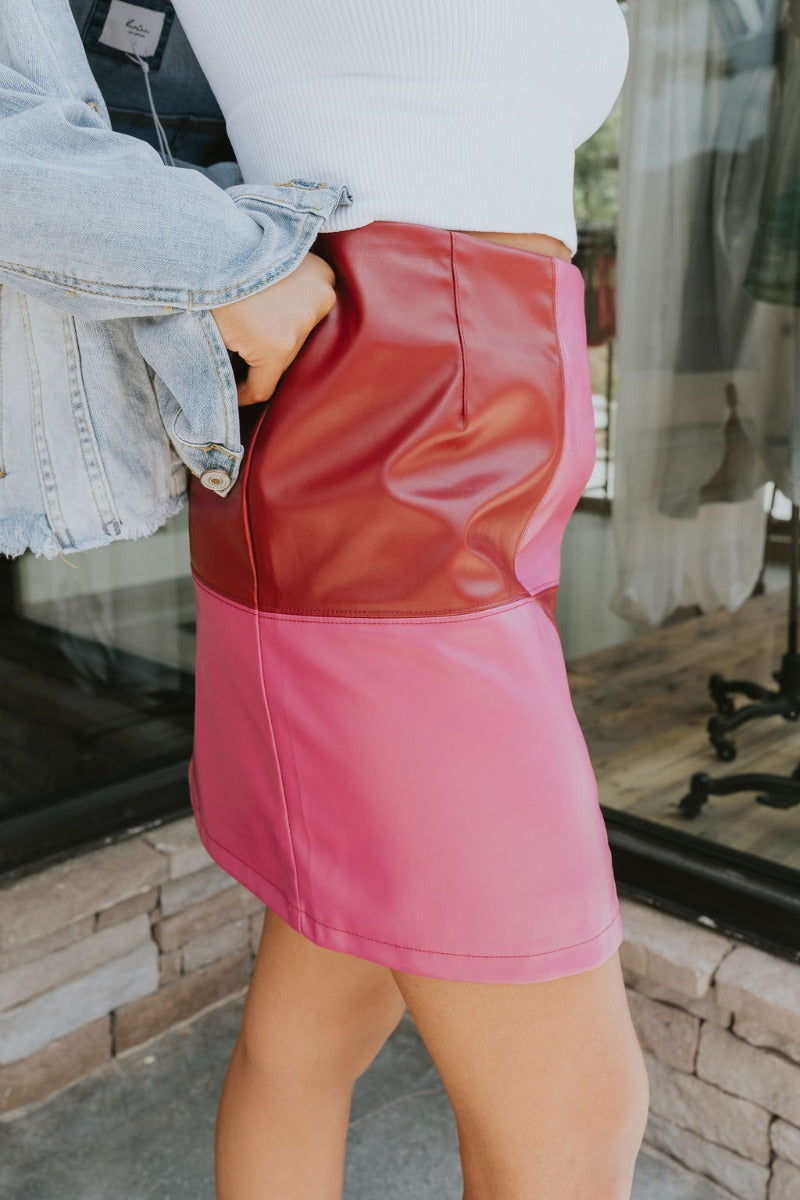 Side view of the Born Diva Color-Block Skirt that features a faux leather material, a color block design, a high-rise waist, and a back zipper closure