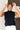 Frontal view of the Meet Me In Maine Sweater Tank that features a black stretchy knit material, a turtleneck, a sleeveless design, and a thick bottom hem.