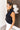 Side view of the Meet Me In Maine Sweater Tank that features a black stretchy knit material, a turtleneck, a sleeveless design, and a thick bottom hem.