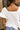 Back view of the Got Your Back Top that features a white gauze material, straight neckline, a short ruffle sleeve, frayed stitching details through out, and a flowy fit.