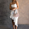 Full body front view of model wearing the Liliana White Asymmetric Sleeveless Midi Dress that has white knit fabric, an asymetrical ruffle hem, midi length, a square neckline, and adjustable straps.
