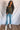 Full body front view of model wearing the Lost Without You Sweater, which features olive open-knit fabric with larger knitting on the sides, a round neckline, long sleeves, and a slouchy fit.