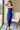 Front view of model wearing the Turn Back Time Midi Dress, which features lined navy fabric, a strapless corset top with boning in the front, a front slit, and a back zipper