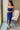 Front view of model wearing the Turn Back Time Midi Dress, which features lined navy fabric, a strapless corset top with boning in the front, a front slit, and a back zipper