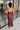 Back view of model wearing the Magic Moment Dress in Burgundy, which features satin fabric with a midi-length hem, burgundy feathers across the neckline, adjustable thin straps, and a back zipper