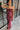 Front view of model wearing the Magic Moment Dress in Burgundy, which features satin fabric with a midi-length hem, burgundy feathers across the neckline, adjustable thin straps, and a back zipper