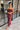 Front view of model wearing the Magic Moment Dress in Burgundy, which features satin fabric with a midi-length hem, burgundy feathers across the neckline, adjustable thin straps, and a back zipper