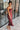 Front view of model wearing the Magic Moment Dress in Burgundy, which features satin fabric with a midi-length hem, burgundy feathers across the neckline, adjustable thin straps, and a back zipper