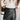 Close-up front view of model wearing the Talk That Talk Skort, which features black faux-leather with silver studs, a front skirt overlay, and a back zipper.