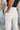 Close-up back view of model wearing the Isabella Corduroy Pants, that feature lightweight cream-colored corduroy, a button + zipper closure, front and back pockets, and wide legs