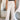 Front view of model wearing the Isabella Corduroy Pants, that feature lightweight cream-colored corduroy, a button + zipper closure, front and back pockets, and wide legs