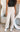 Front view of model wearing the Isabella Corduroy Pants, that feature lightweight cream-colored corduroy, a button + zipper closure, front and back pockets, and wide legs