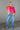 Full body front view of model wearing the Noa Color Block Long Sleeve Sweater that has a pink, yellow, and orange color block pattern, long balloon sleeves with ribbed wrists, a round neckline, and oversized fit.