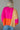 Back view of model wearing the Noa Color Block Long Sleeve Sweater that has a pink, yellow, and orange color block pattern, long balloon sleeves with ribbed wrists, a round neckline, and oversized fit.