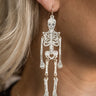 Side view of model wearing the Sally White Glitter Skeleton Earrings that feature white glitter skeleton shaped dangle earrings with gold link details.