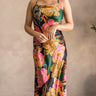 Full body view of model wearing the Elise Multi Floral Satin Midi Dress which features black, green, pink, orange, turquoise, beige and dark yellow satin fabric, floral print, midi length, cowl neckline, adjustable straps, corset back ties and sleeveless.