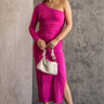 Full body front view of model wearing the Dahlia Pink One-Shoulder Ruched Midi Dress that has lightweight pink knit fabric, a one-shoulder neckline with 1 long sleeve, a back cutout, ruched sides, and a side slit.