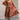 Full body front view of model wearing the Wrenley Rust Long Sleeve Midi Dress that has rust gauze fabric, a tiered body, long balloon sleeves with elastic, side pockets, a v neck, and a smocked back.