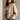 Frontal side view of model wearing the Nova Taupe Knit Quilt Jacket which features taupe cable knit fabric and taupe quilted fabric, two front slit pockets, brown tortoise buttons, a high neckline with a hood attached, and long puff sleeves with cuffs.