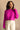 Front view of model wearing the Aria Fuchsia Long Sleeve Sweater which features fuchsia textured knit fabric, ribbed trim, a cropped waist, a round neckline, dropped shoulders, and long sleeves with ribbed trim.