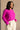 Frontal side view of model wearing the Aria Fuchsia Long Sleeve Sweater which features fuchsia textured knit fabric, ribbed trim, a cropped waist, a round neckline, dropped shoulders, and long sleeves with ribbed trim.