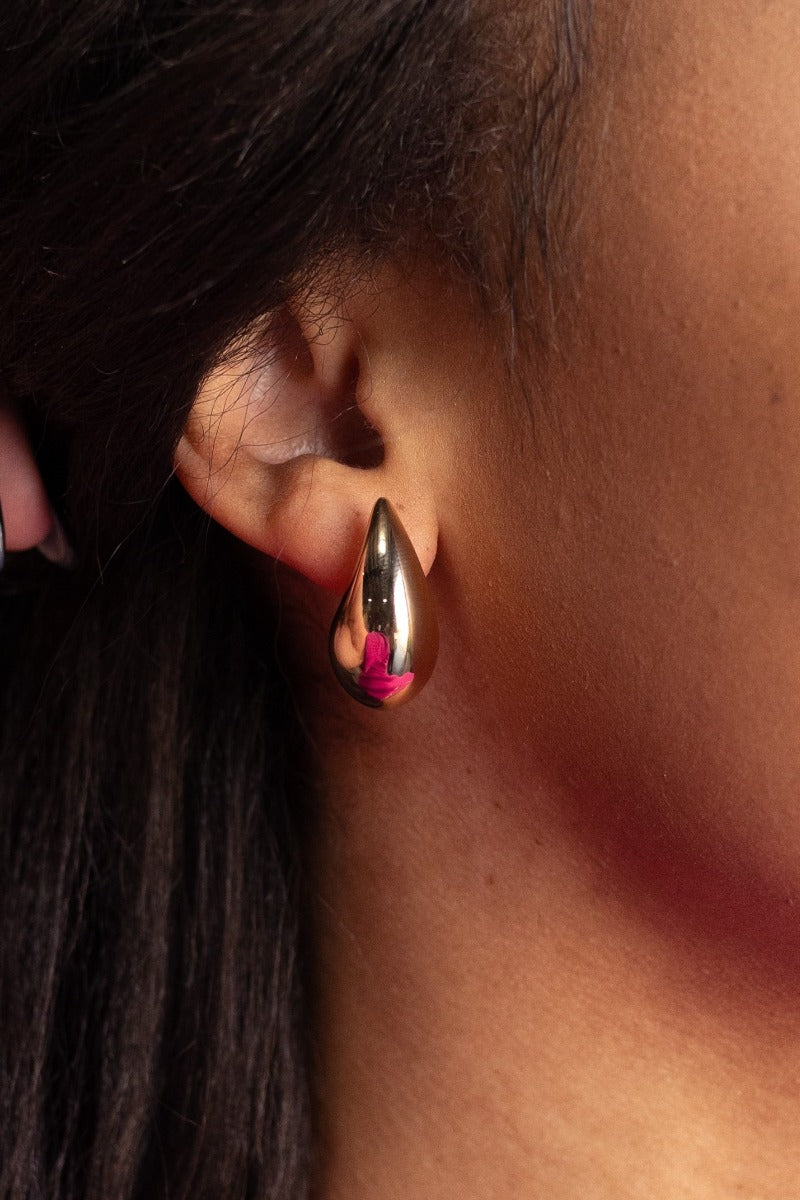 Close up of model wearing the Claire Gold Teardrop Stud Earrings that features thick gold scooped studs.
