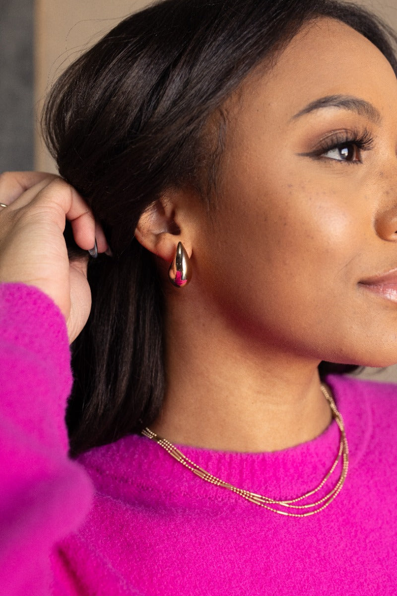 Side view of model wearing the Claire Gold Teardrop Stud Earrings that have thick gold scooped studs.