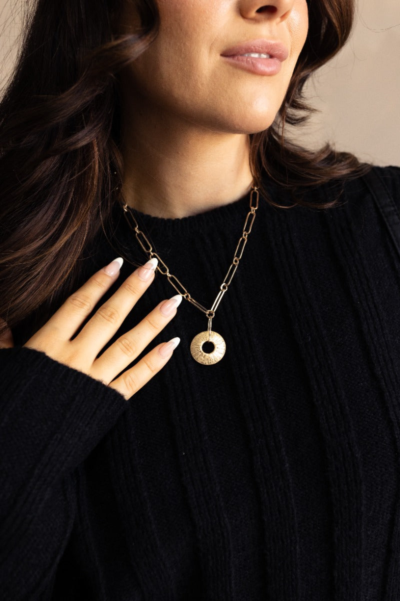 Front view of model wearing the Solana Gold Medallion Necklace that features one gold chain layer with an open circle medallion.