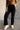 Front view of model wearing the Aubrey Black Lounge Pants which features black cotton fabric, two front pockets, an elastic waistband with drawstring ties, and wide legs.