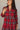 Front view of model wearing the Victoria Red Multi Plaid Tiered Mini Dress which features red cotton fabric with a dark blue, light blue, green and white plaid pattern, mini length, two-tiered body style, a round neckline with a v cut-out, a tie closure a