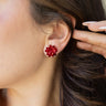 Side view of model wearing the Bella Red Bow Stud Earrings that feature red studs shaped as a present bow.