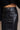 Close upper front view of model wearing the Danna Black Faux-Leather Slit Front Midi Skirt that has black faux leather, a zip up front, a front slit, two front pockets, and midi length.