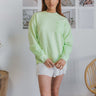 Front view of model wearing the Let's Go Sweatshirt which features light green fabric, side zipper design, zipped pocket on the chest, round neckline and long sleeves.
