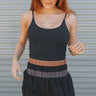 Front view of model wearing the Walk The Line Shorts that have black and grey lightweight fabric, high waisted with smocked details, black brown and grey color-block details and black panty lining