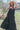 Front view of model wearing the Definitely You Maxi Dress which features black fabric, maxi length, multi tiered body. v neckline and double spaghetti straps that cross in the back.
