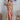 Full body view of model wearing the Destination Trip Dress which features pink, orange, yellow, green and white fabric, floral pattern, maxi dress, tiered body style, smocked chest, ruffle sweetheart neckline and tie straps.