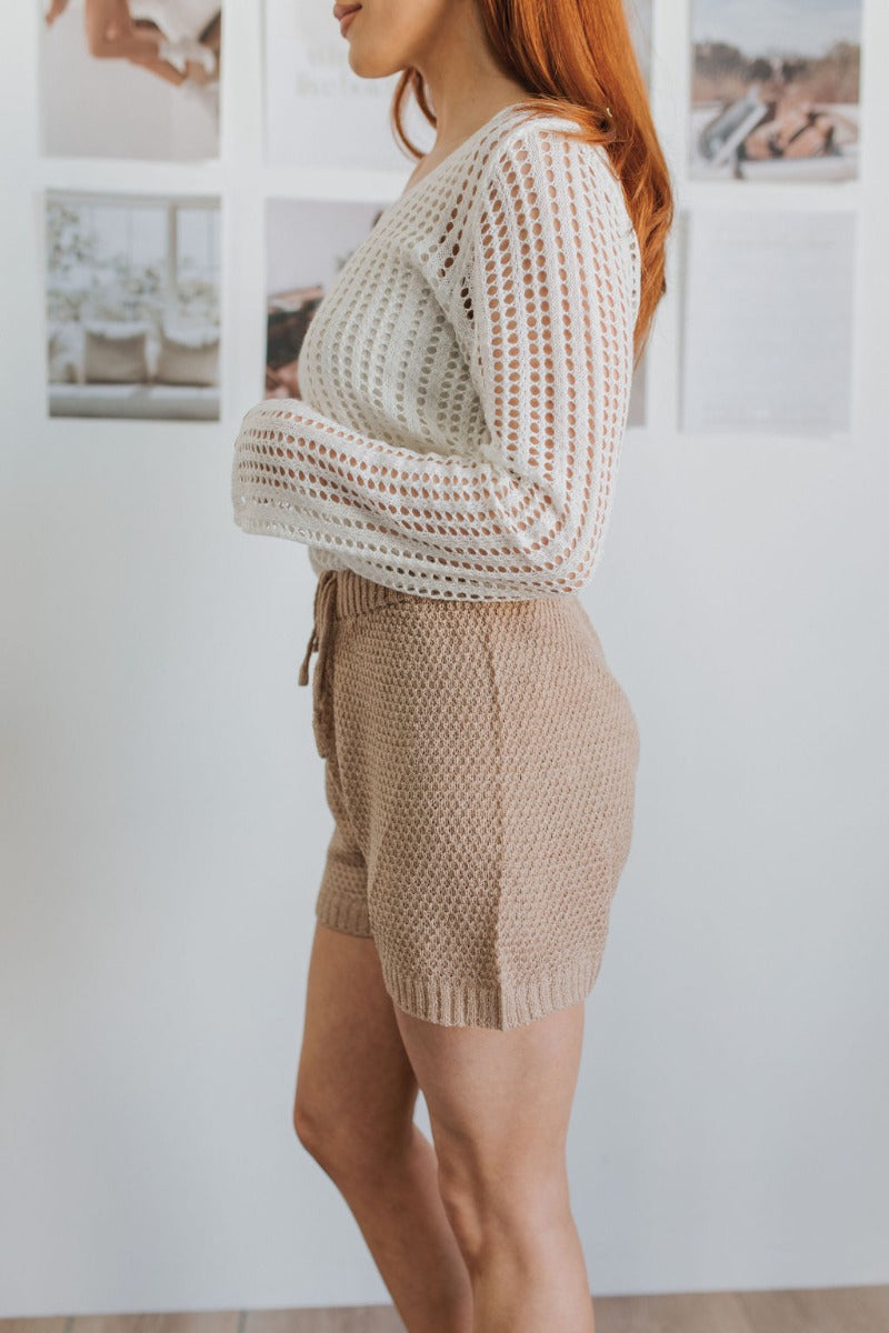 Side view of model wearing the Everyday Dreams Shorts which features taupe knit fabric and elastic waistband with drawstring ties.
