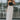 Full body front view of model wearing the Trend Setter Cargo Midi Skirt that has taupe light weight fabric, side cargo pockets, an elastic waist with a black drawstring tie, two upper pockets and a back slit