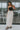 Full body front view of model wearing the Trend Setter Cargo Midi Skirt that has taupe light weight fabric, side cargo pockets, an elastic waist with a black drawstring tie, two upper pockets and a back slit