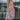 Full body front view of model wearing the Pacific Coast Floral Midi Dress that has purple, orange, pink, green, blue and cream fabric, floral and palm leaf print, and adjustable straps.