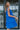 Side view of model wearing the Summer Shade Romper that has cobalt blue fabric, a two-tiered body, a scooped neckline, and tie straps.
