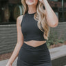 Front view of model wearing the Get Obsessed Skort in Black that has black fabric, a mini length hem, shorts lining, and an overlapped waistline.
